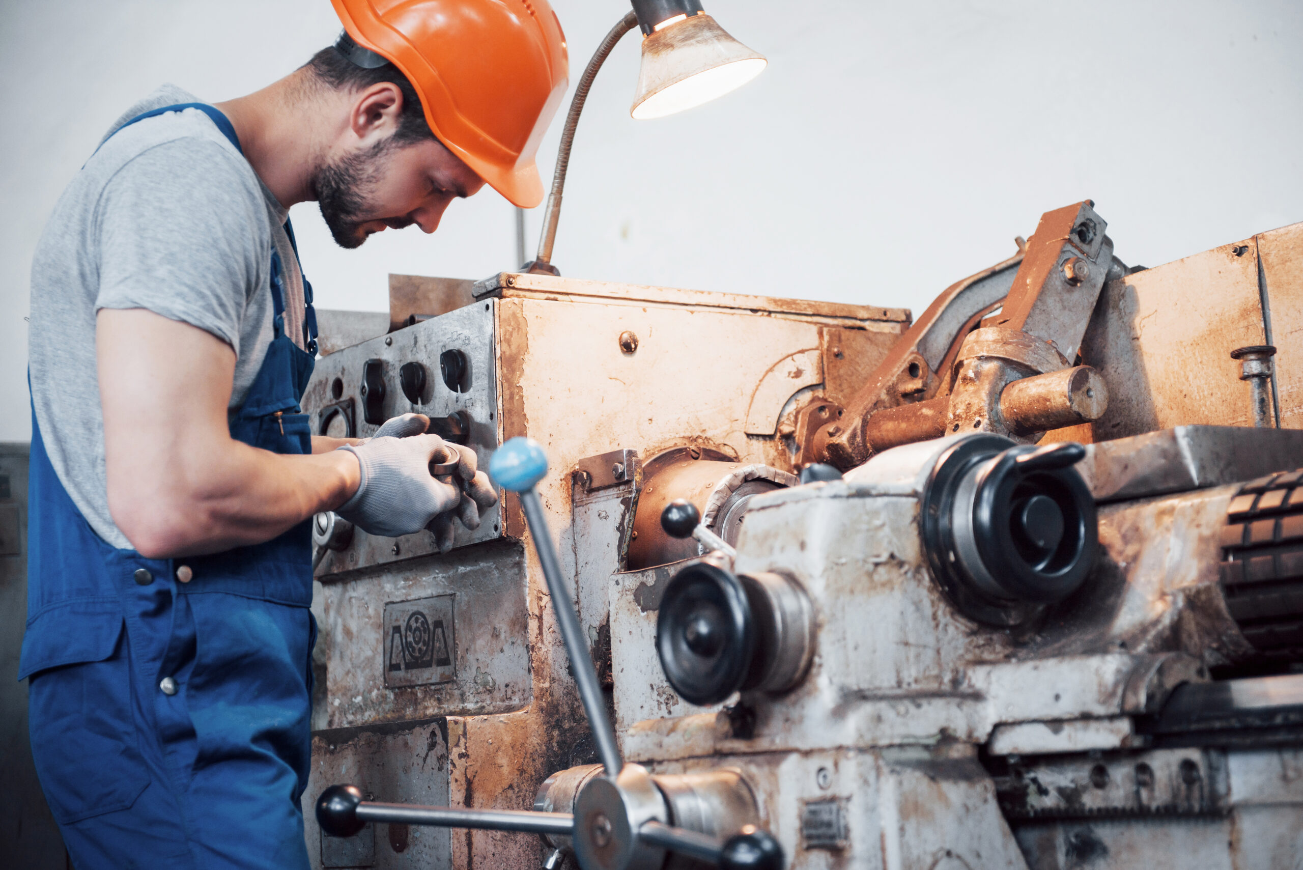 portrait of a young worker in a hard hat at a large metalworking plant. the engineer serves the machines and manufactures parts for gas equipment